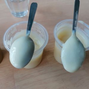 Deux pots de yaourt ouverts avec une cuillère sur chacun