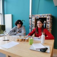 Deux jeunes personnes assises autour d'une table faisant un test  de dégustation de yourts.